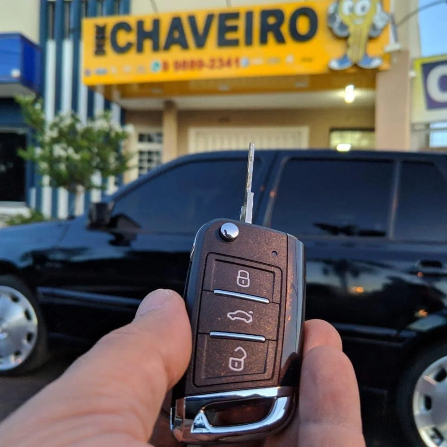 Chave automotiva com a fachada da Disk Chaveiro ao fundo